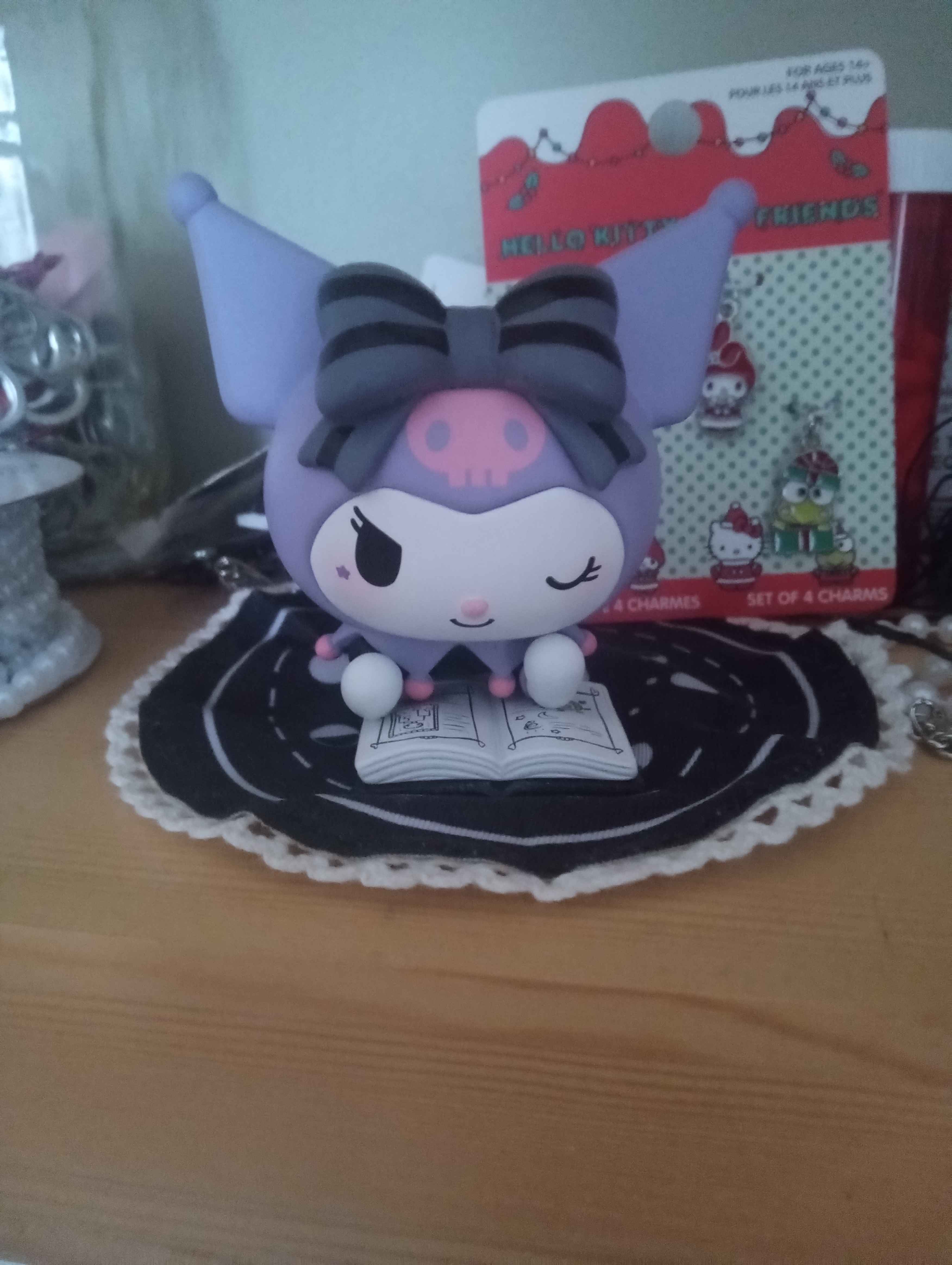 a figure of kuromi lying on a rug with a mysterious book